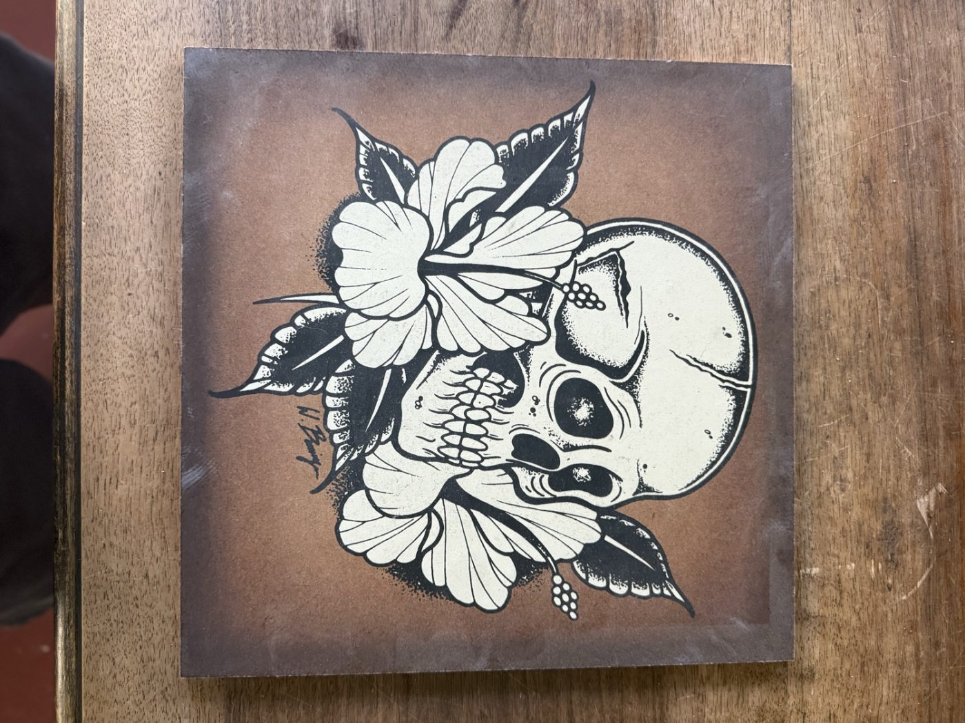Holztafel mit Tattoo-Flash, Totenkopf und Hibiskus