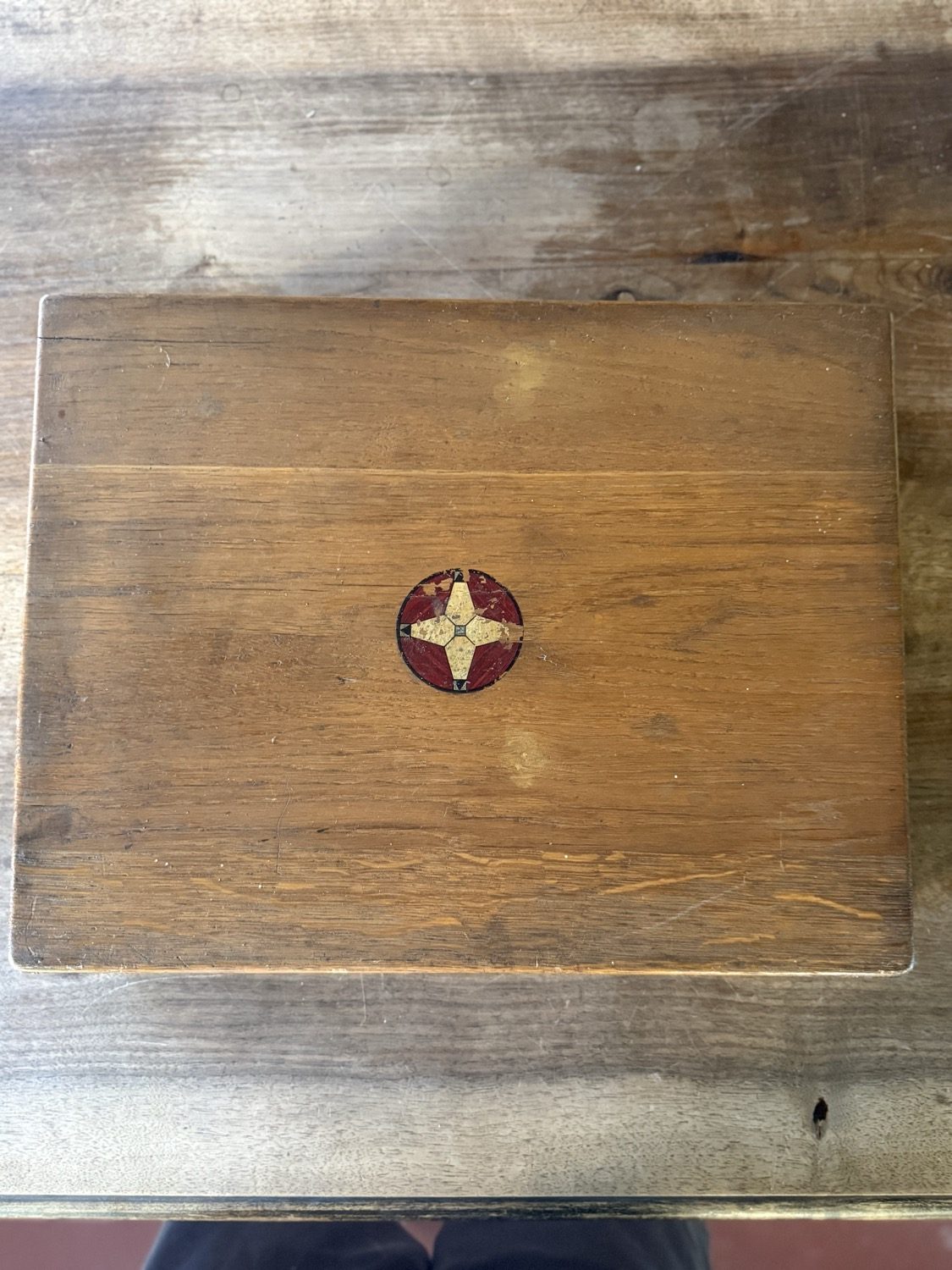 Flache Holzkiste mit gemaltem Emblem